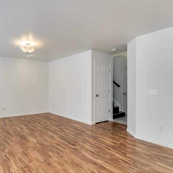 a room with wooden flooring and a white door.