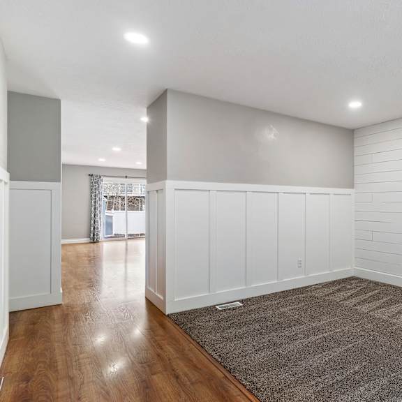 a room with white walls and a grey carpet.