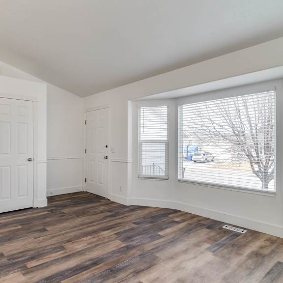a room with a staircase and a window overlooking a street.