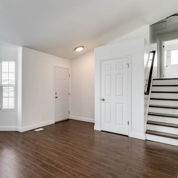 a room with a wooden floor and a staircase.