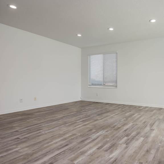 a room with wooden flooring and white walls.