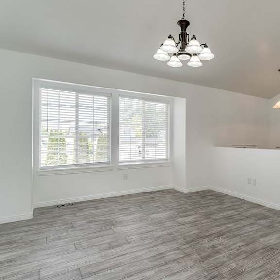 a room with a staircase and a window with blinds.
