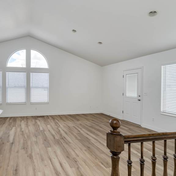 a living room with a staircase and a large window