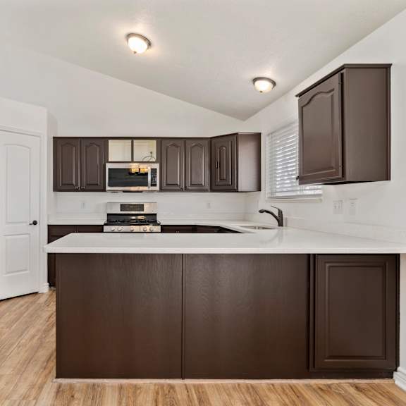 a kitchen with brown cabinets and a white counter.