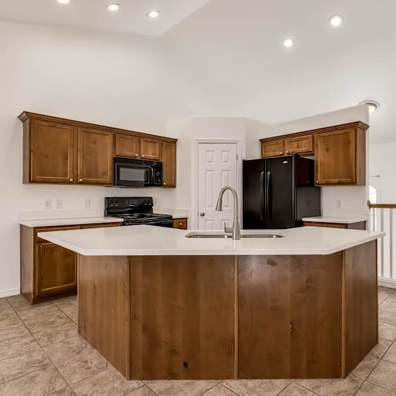 a kitchen with a white counter top and wooden cabinets.