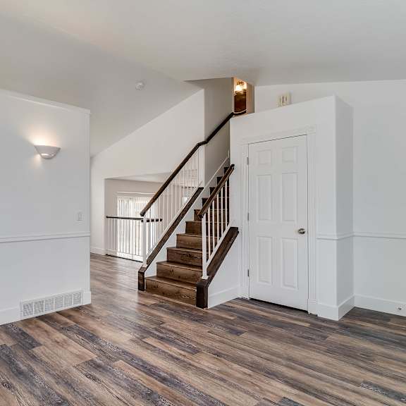 a white door is on the right side of a staircase.