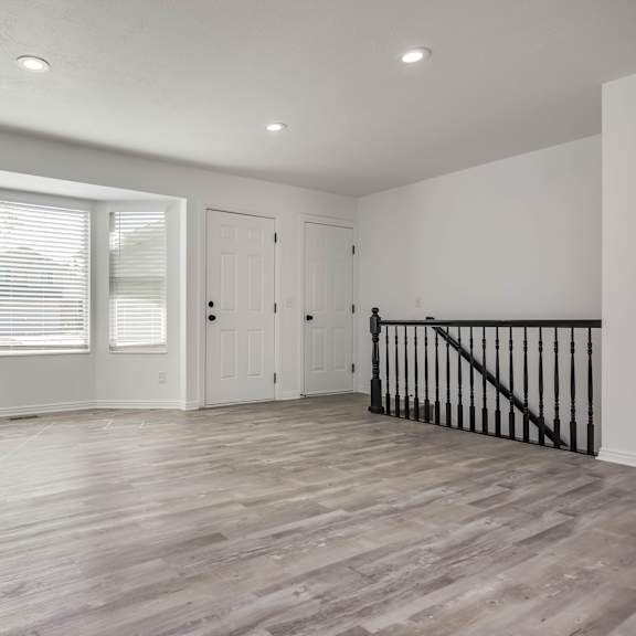 a room with wooden flooring and white walls.