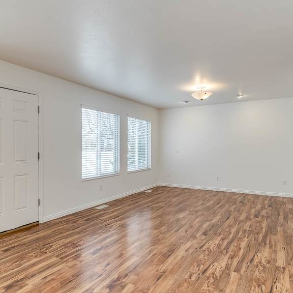 a room with wooden flooring and white walls.