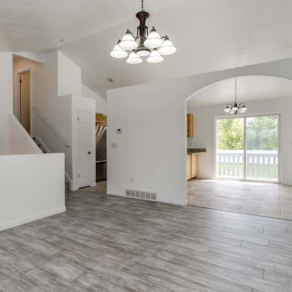 a large, empty room with a staircase and a chandelier.