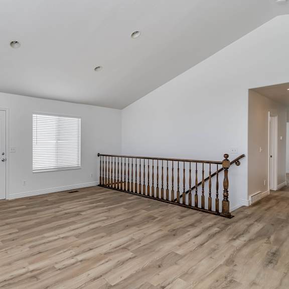 a living room with hardwood floors and a staircase     and a