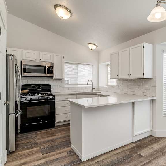 a kitchen with white cabinets and a black stove top oven.
