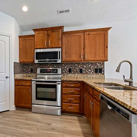a kitchen with wooden cabinets and stainless steel appliances.