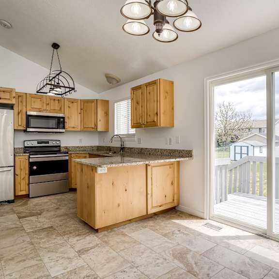 a kitchen with wooden cabinets and a tiled floor.