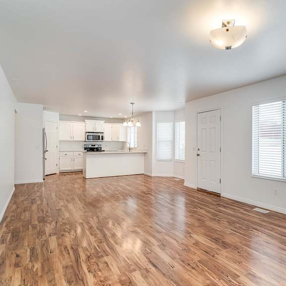 a spacious room with wooden floors and white walls.