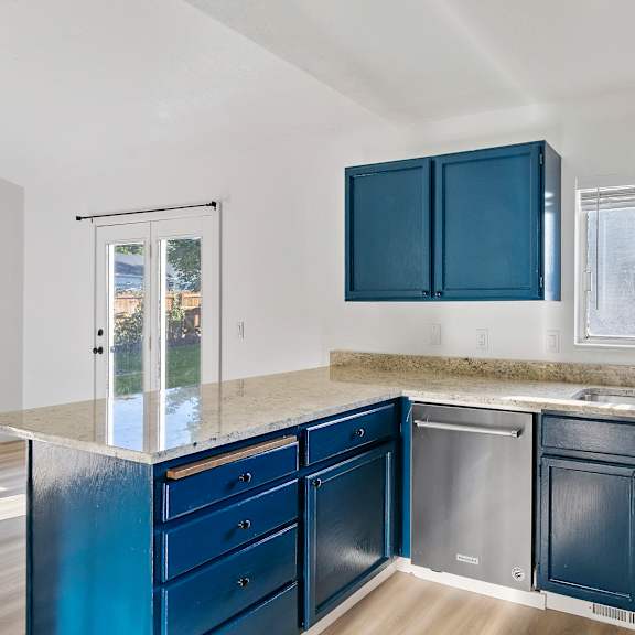 a kitchen with blue cabinets and a sink and a window