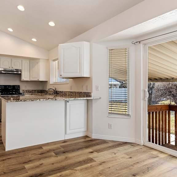 a kitchen with an island and a door to a balcony
