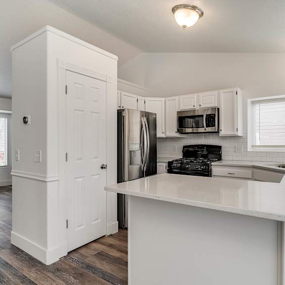 a kitchen with white cabinets and a white island.