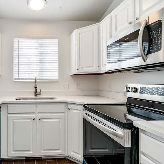 a kitchen with white cabinets and black appliances.