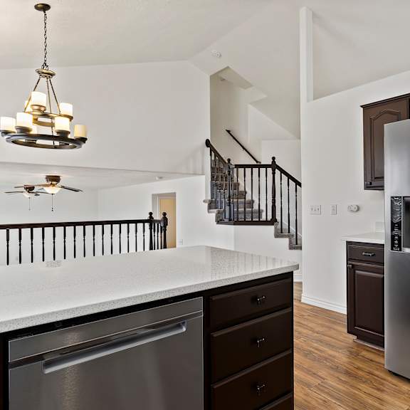 a modern kitchen with a stainless steel refrigerator and a ceiling fan.
