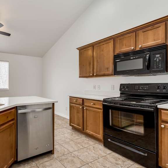 a kitchen with a stove, sink, and cabinets.