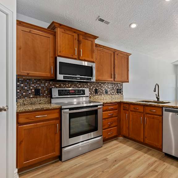 a kitchen with wooden cabinets and stainless steel appliances.