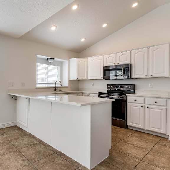 a large kitchen with white cabinets and a counter top