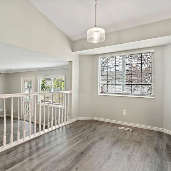 an empty living room with a staircase and a window