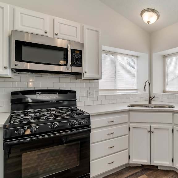 a kitchen with white cabinets and a black stove top oven.