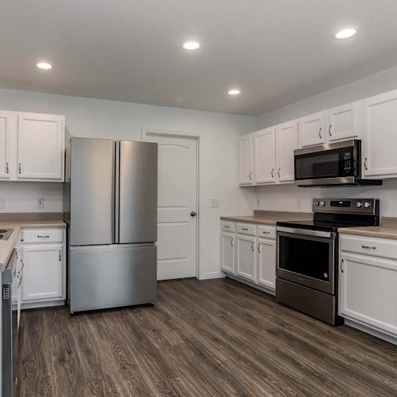 a kitchen with white cabinets and a stainless steel refrigerator.