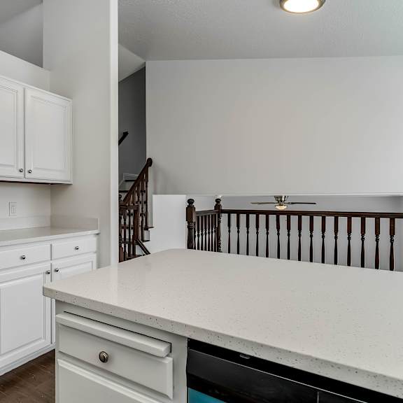 a kitchen with white cabinets and a stainless steel refrigerator.