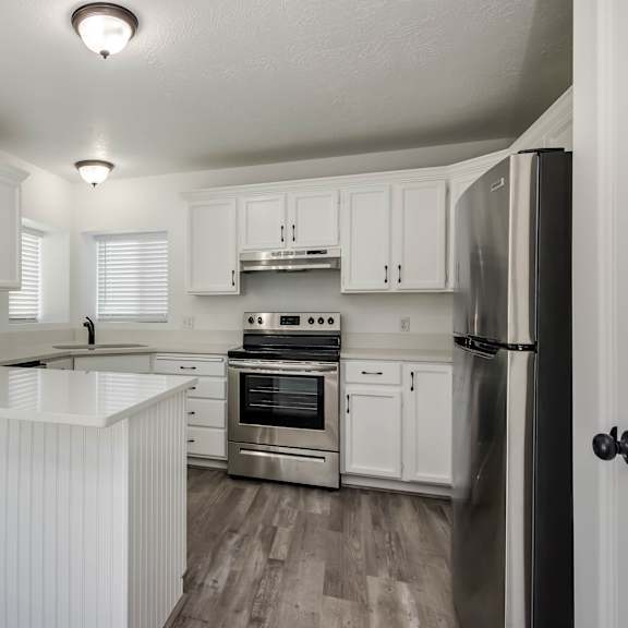a kitchen with white cabinets and stainless steel appliances.