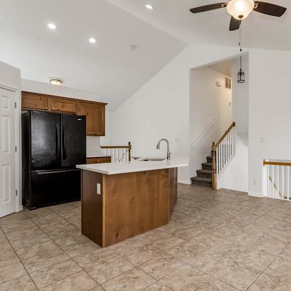 a spacious living room with a kitchenette and a staircase.