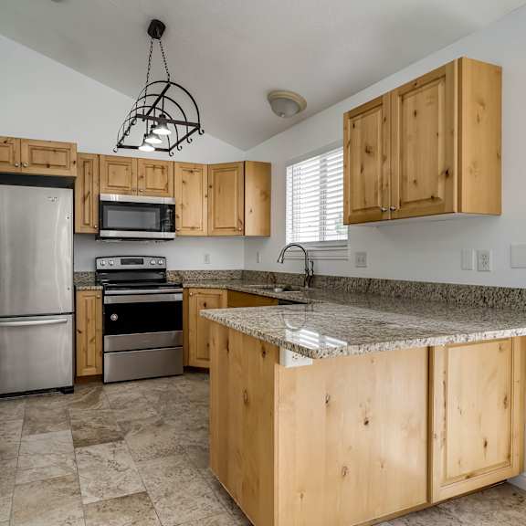 a kitchen with wooden cabinets and granite countertops.