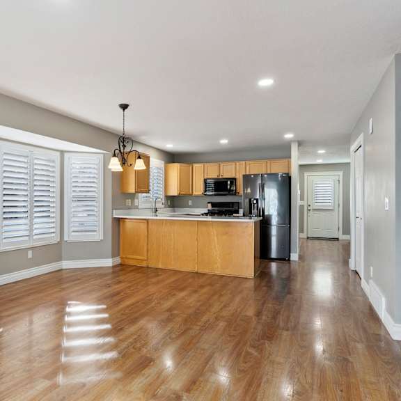 a kitchen with wooden floors and a countertop with a sink.