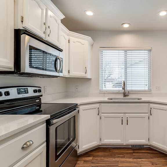 a kitchen with white cabinets and appliances.