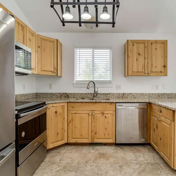 a kitchen with wooden cabinets and granite countertops.