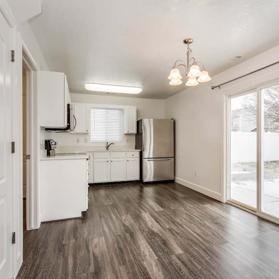 an empty kitchen with a large window and a door to a yard