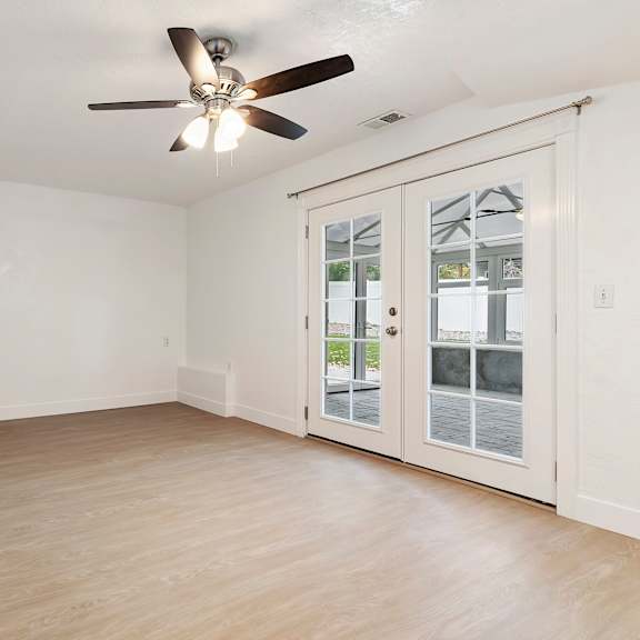 a room with a ceiling fan and a staircase.