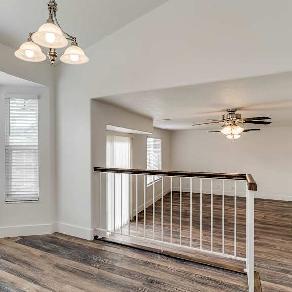 a room with a wooden floor and a white railing.