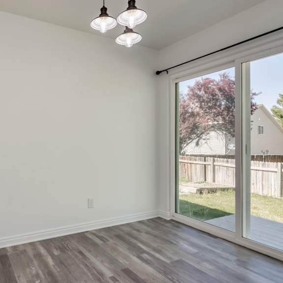 a room with a sliding glass door leading to a backyard.