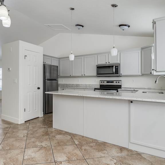 a kitchen with white cabinets and appliances.