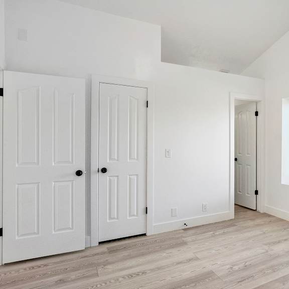 an empty room with white walls and white doors and a window