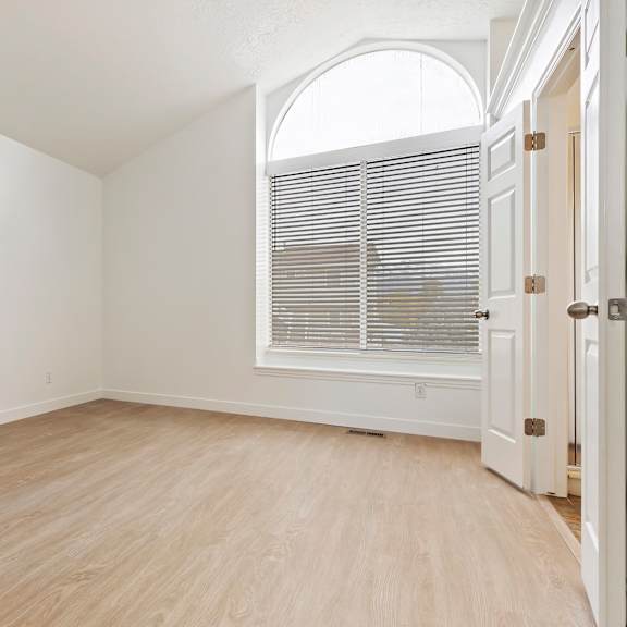 a room with a white door and a window with blinds.