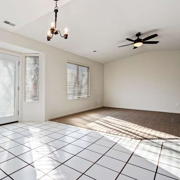 an empty living room with a sliding glass door to a patio