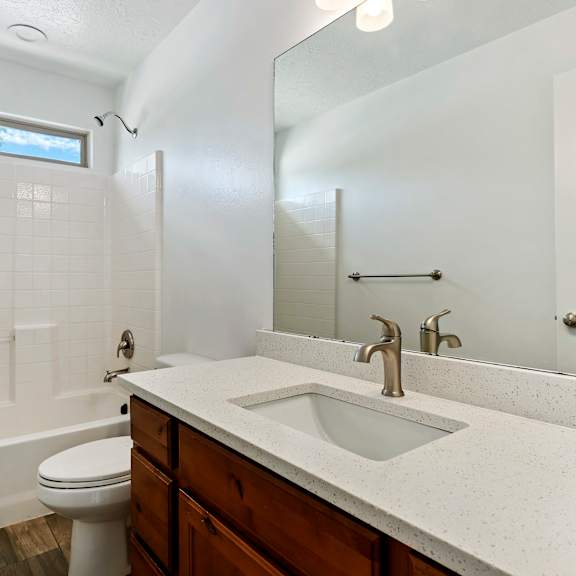 a white bathroom with a toilet, sink, and bathtub.