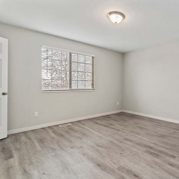 an empty room with white walls and a window