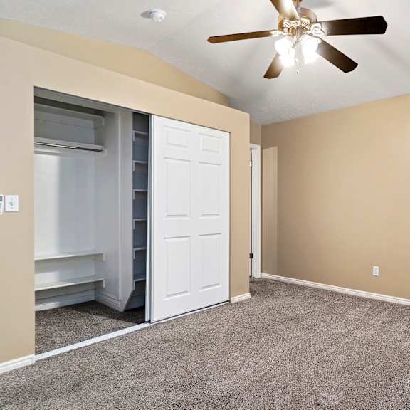 a room with a ceiling fan and a carpeted floor.