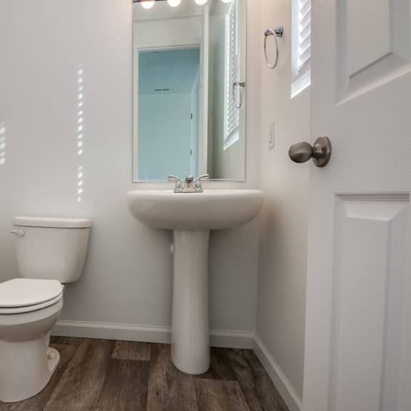 a white toilet and sink in a bathroom.