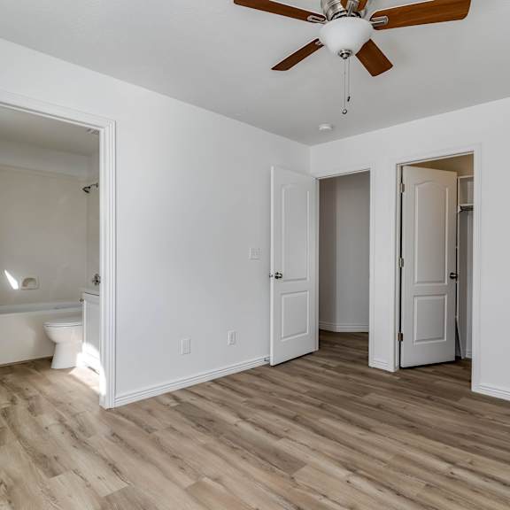 a living room with white walls and a ceiling fan