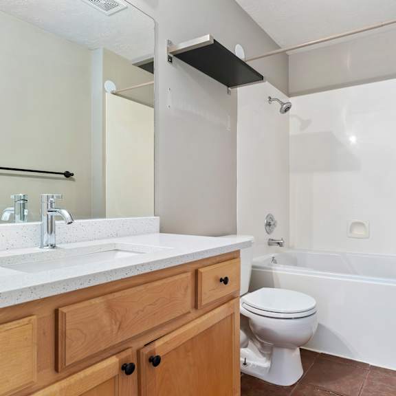 a white bathroom with a toilet, sink, and bathtub.